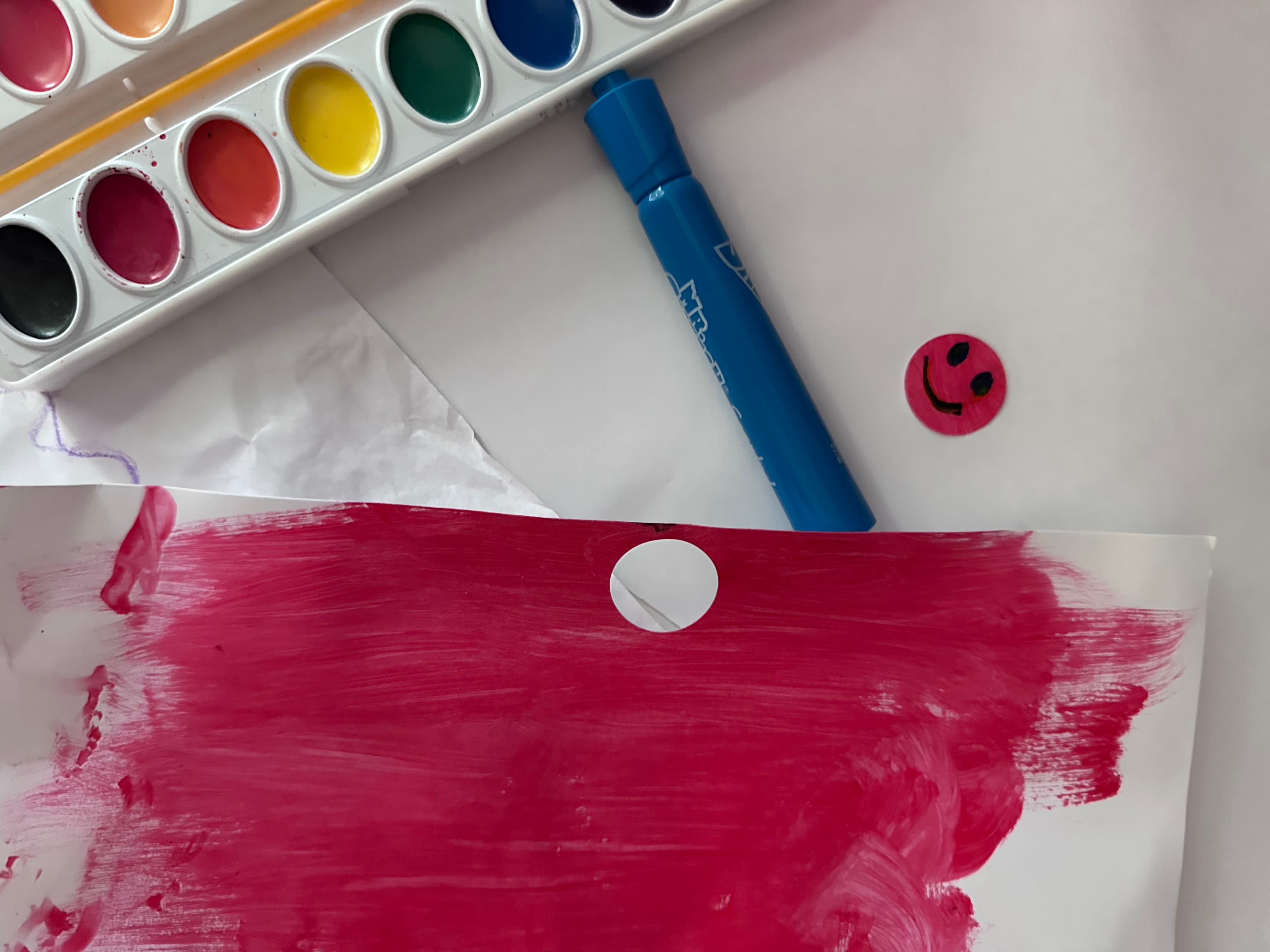 Child painting with colorful art supplies